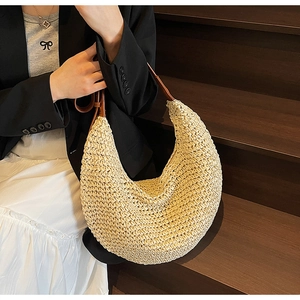 Close-up of woven hobo bag texture with dark brown leather adjustable shoulder strap