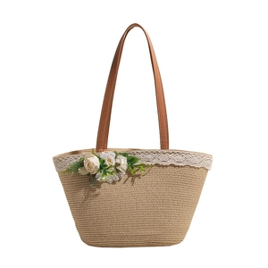 Handmade woven straw tote bag with brown leather handles and decorative white roses