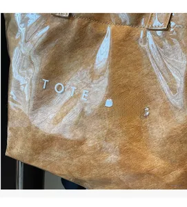 Détail du sac cabas en PVC transparent avec couche interne marron et lettrage blanc chic