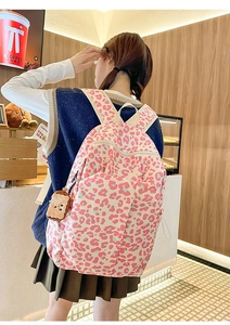 Detailed side view of pink leopard print backpack with cute plush toast accessory