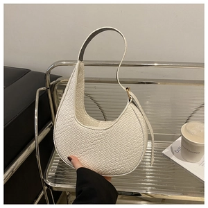 Minimalistische weiße Halbmond-Schultertasche mit Webmuster auf Metallständer präsentiert