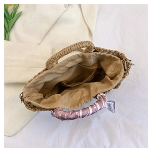 Internal view of straw handbag with khaki woven texture, floral scarf and inner pocket