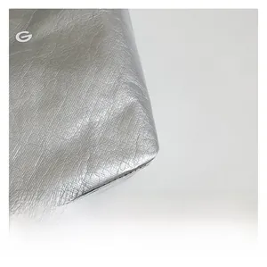 Macro detail of waterproof silver DuPont paper texture featuring a white G letter logo