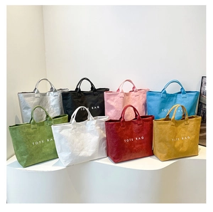 Selection of minimalist Tyvek tote bags in eight vibrant colors on white display stands