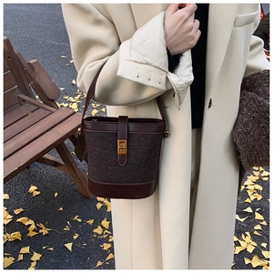 Détail d'un sac seau marron foncé en tissu léopard avec un fermoir doré élégant