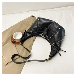 Détail du sac demi-lune vintage noir avec rivets dorés et texture de cuir PU raffiné