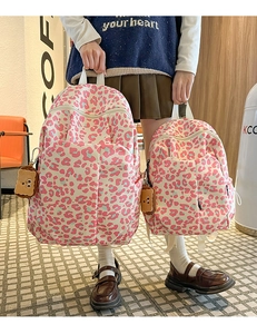 Detail showing pink leopard print backpacks with cute plush toast bear charms for girls