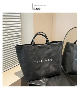 Detail of black tote bag with textured DuPont paper and white TOTE BAG lettering