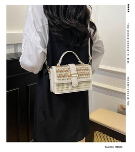 Dettaglio borsa a tracolla in paglia con pelle beige e trame intrecciate alla moda