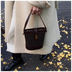 Détail du sac seau à motif léopard avec poignées en cuir et fermoir doré chic