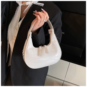 Detail showing white crocodile embossed leather texture on hobo bag with dual zipper closure