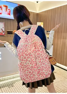 Detail showing pink leopard print backpack with a cute toast plush charm in a cafe