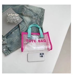Detail view of mini transparent PVC tote bag with vibrant pink trim and blue handles