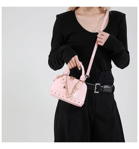 Detailansicht der rosa Muscheltasche mit Goldkette und schützenden Boden-Nieten