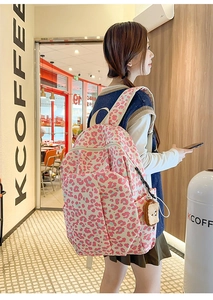Detail view of pink and blue leopard print backpack with cute toast plush charm