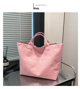 Detailed macro shot of textured pink Dupont paper tote bag with printed lettering