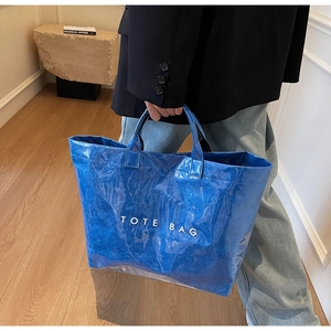 Détail du sac cabas bleu double couche avec extérieur en PVC et logo blanc imprimé