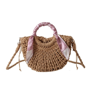 Handmade woven straw half-moon handbag with decorative pink silk scarf and shoulder strap