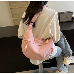 Detailed texture of pink corduroy fabric on a stylish crescent-shaped crossbody bag