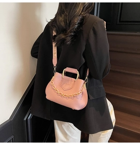 Pink lychee texture bucket bag shown with jacquard wide shoulder strap and metal handle