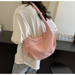 Detail of pink corduroy crossbody bag texture and decorative zipper pullers