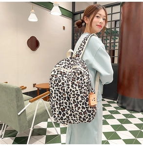 Detailed view of fashionable leopard print backpack with a cute plush toast accessory