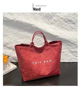 Detail of red crumpled texture tote bag with white TOTE BAG lettering on a wooden desk