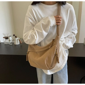 Detail of light brown corduroy crescent bag showing vertical texture and knot strap