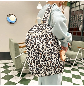 Close-up of leopard print backpack with toast plush charm and durable side pockets