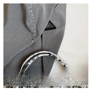 Detail of grey fabric handbag showing contrast stitching and snakeskin pattern handle