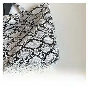 Detail of the high-quality snakeskin pattern texture and BAG logo on the large tote bag