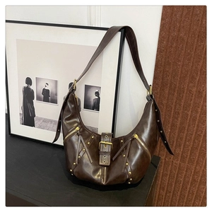 Détail du sac hobo en cuir marron foncé avec fermetures dorées et clous en métal