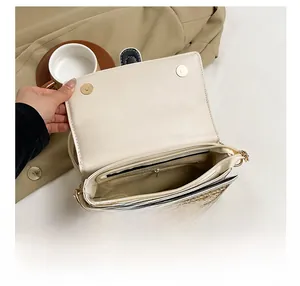 Dettaglio degli scomparti interni multistrato e chiusura magnetica della borsa in paglia
