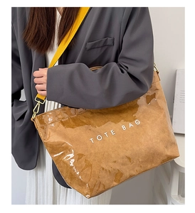 Detail of waterproof PVC tote bag with brown crinkled texture and yellow shoulder strap