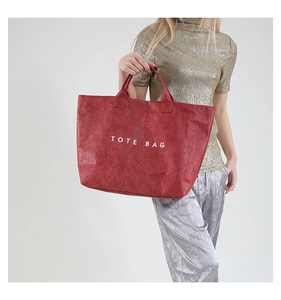 Detail view of the red wrinkled texture fabric and white TOTE BAG lettering print
