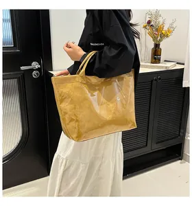 Detail of waterproof yellow tote bag with clear PVC layer and white TOTE BAG text print