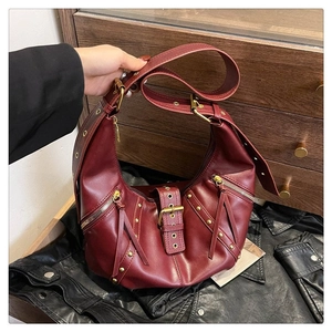 Détail du sac demi-lune bordeaux avec rivets vintage et bandoulière réglable