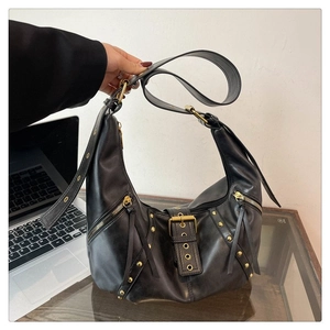 Détails du sac demi-lune en cuir noir avec rivets dorés, zips et boucle métallique
