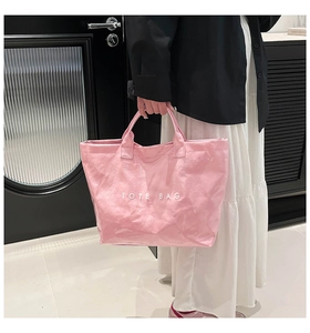Detailed view of waterproof pink tote bag with glossy finish and white printed text