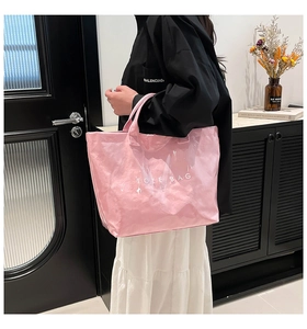 Detailed view of the pink waterproof DuPont paper tote bag held by a model in a casual setting