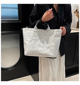 Detail of waterproof Tyvek tote bag featuring a textured finish and embossed lettering