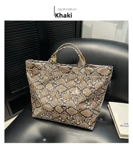 Detail view of khaki snake print tote bag with white TOTE BAG text on leather seat