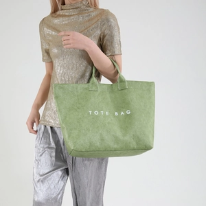 Minimalist green tote bag with white TOTE BAG text shown on a fashion model