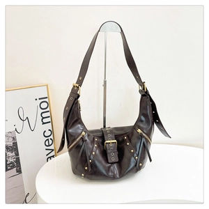 Gros plan détaillé d'un sac demi-lune vintage marron foncé avec rivets dorés et zips