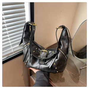 Vue détaillée du sac croissant noir avec rivets dorés vintage et boucles de ceinture