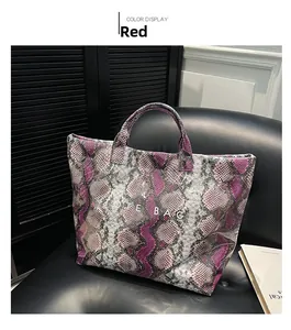 Detail of snake print tote bag in purple and grey with white TOTE BAG lettering text