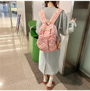 Detail of trendy leopard print backpack showing pink and blue patterns with a cute toast charm