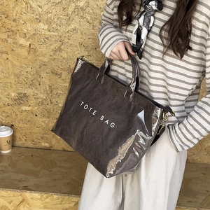 Chic dual-layer transparent PVC and brown fabric tote bag shown on a model