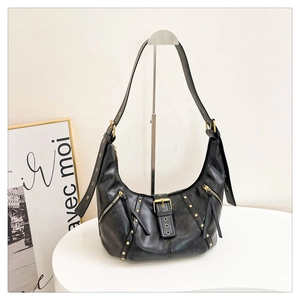 Détail du sac demi-lune en cuir noir mat avec des clous argentés et une boucle décorative