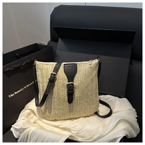 Detail of summer straw bag with V-shaped texture, black leather strap, and golden buckle